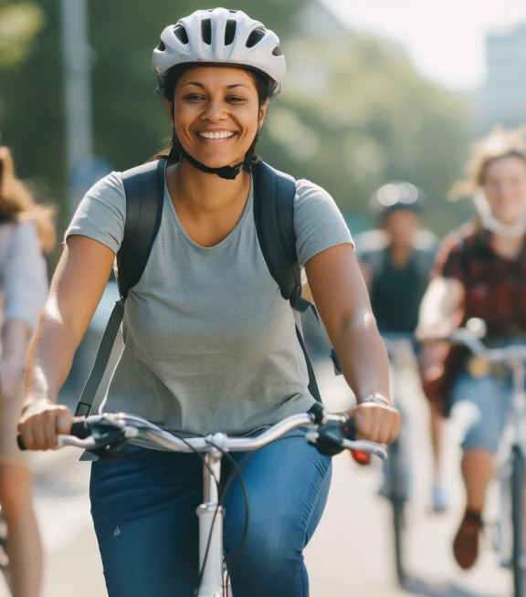 A woman smiles as she rides her bike in a group activity